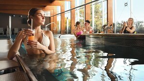 Un espace piscine avec une eau claire, des chaises longues et un bar.