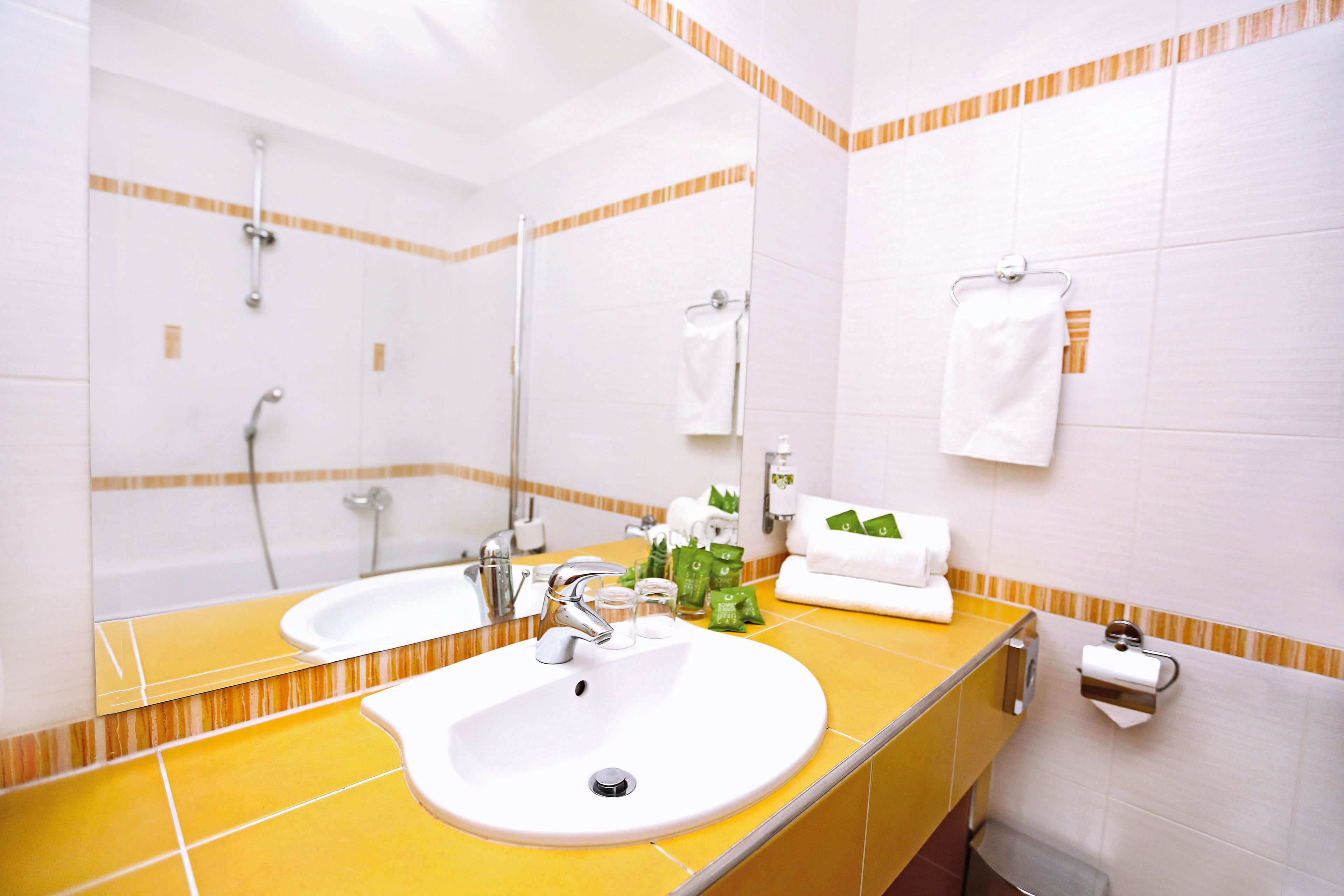 Un baño con dos lavamanos, un espejo y un perchero para toallas.