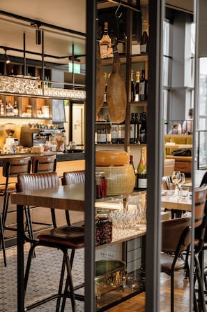 A restaurant interior with a bar area, seating, and a wine rack. - Art hotel Pallas by Tartuhotels (Tartu)