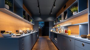A modern kitchen with blue cabinets, wooden countertops, and various food items. - Art hotel Pallas by Tartuhotels (Tartu)