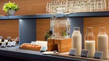 Mostra de buffet amb una varietat d'aliments i begudes, incloent ous, llet i suc.