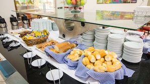 Montaje de bufé con diferentes alimentos, platos y utensilios para servir.