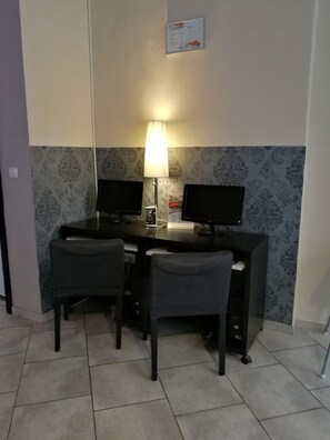 A small office with two desks, two chairs, a lamp, and a wall-mounted sign. - Hotel PurPur (Prague)