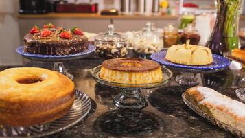 A variety of desserts on display, including cakes and pastries, on a marble countertop.