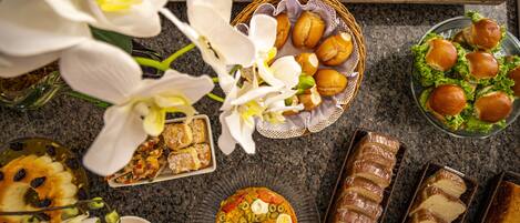 A variety of food items including bread, sandwiches, and a decorated cake on a table.