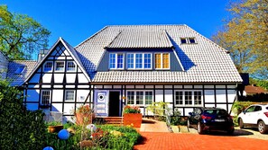 A traditional half-timbered house with a tiled roof and multiple windows.