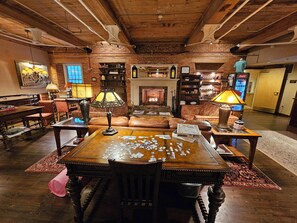 A cozy living room with a fireplace, leather furniture, and a coffee table with a puzzle. - The Common Man Inn & Restaurant (Claremont)