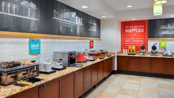 A bakery counter with a chalkboard menu, a sign for bakery items, and a waffle display.