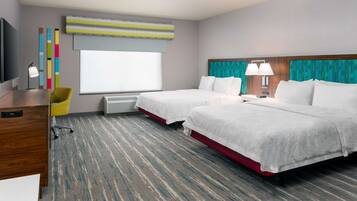 A hotel room with two beds, a desk, a chair, a TV, and a window with blinds.