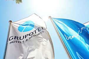 Dos banderas, una con la inscripción "GRUPOTEL HOTELS & RESORTS" y la otra con "denvi".