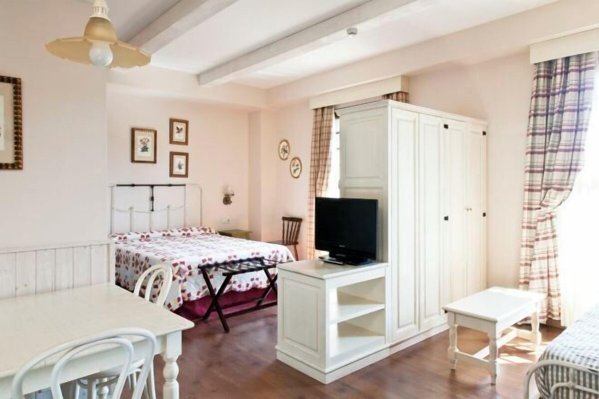 Une chambre à coucher comprenant un lit, une télévision, une armoire, un bureau et une chaise.