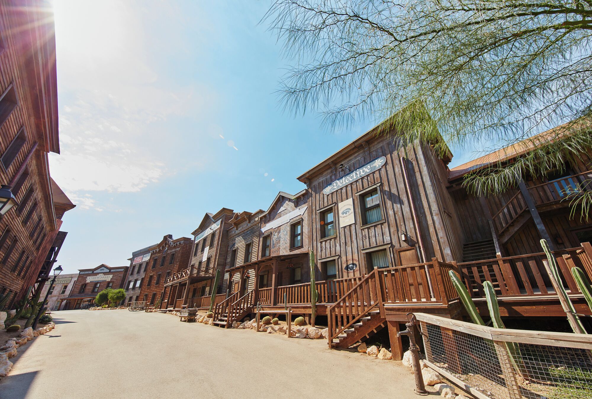 A row of wooden buildings with balconies and a street in between.