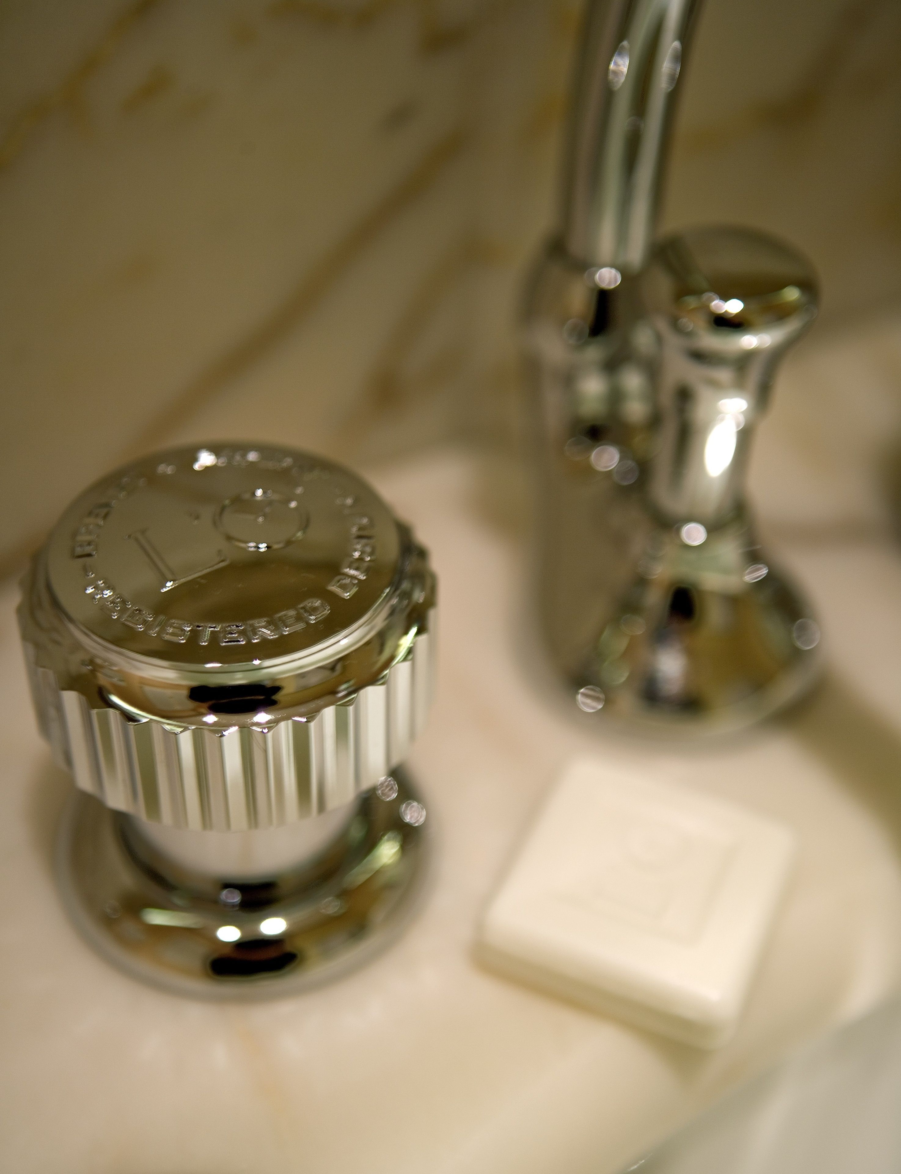 Un grifo de baño con acabado metálico y un jabonera.