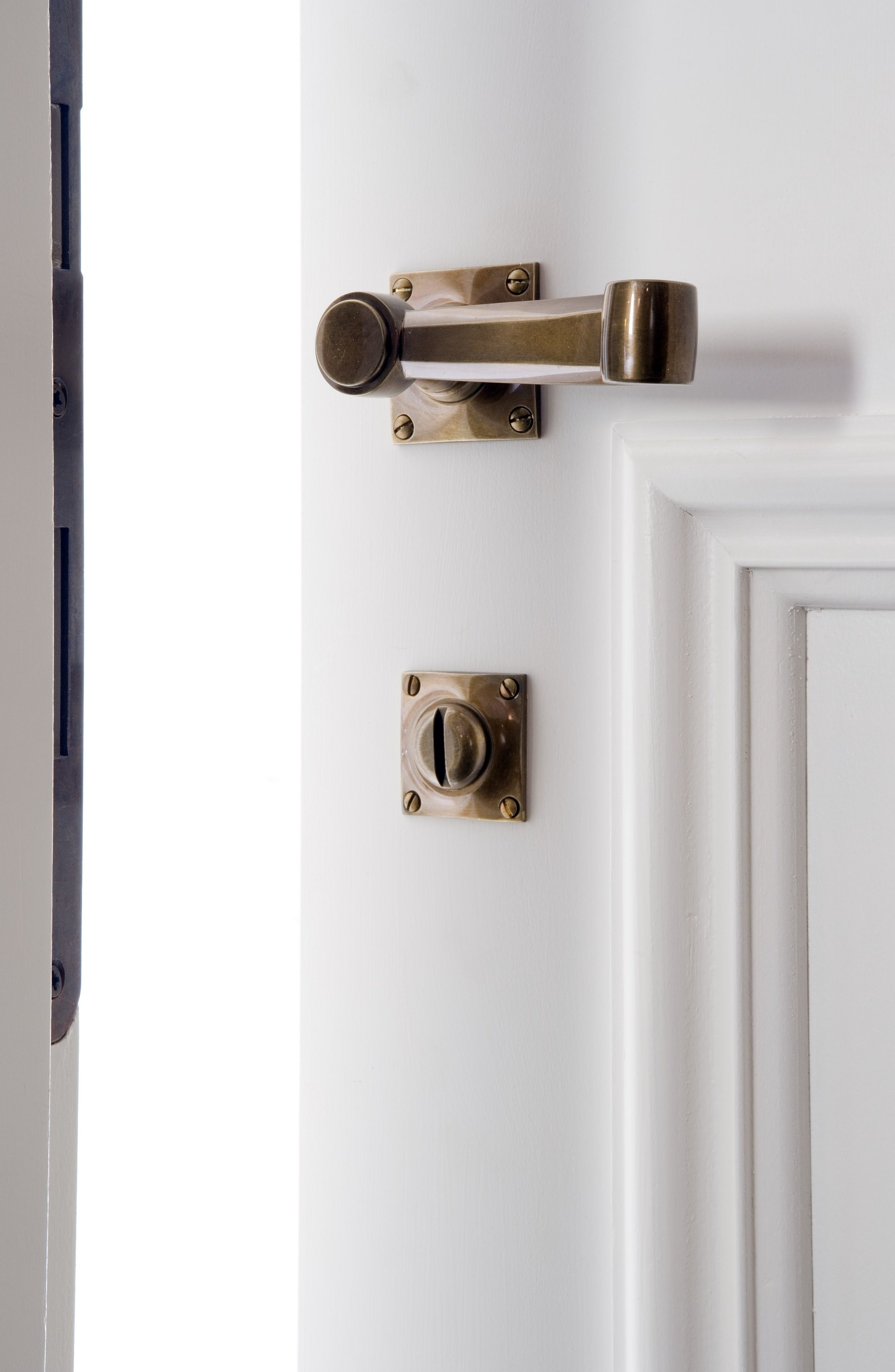 A white door with a brass door handle and a keyhole.
