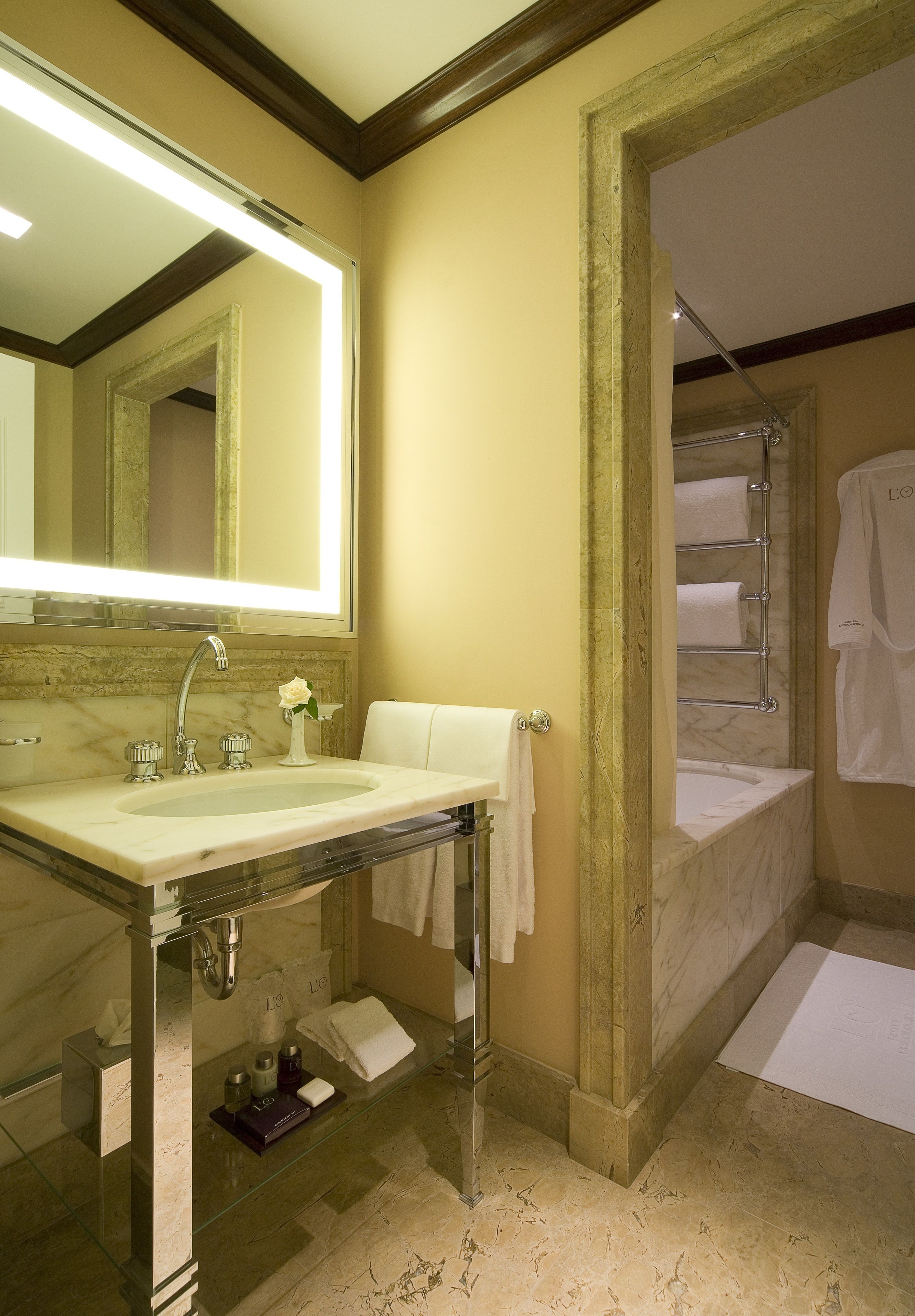 A bathroom with a marble sink, a large mirror, a glass-enclosed vanity, and a shower area.