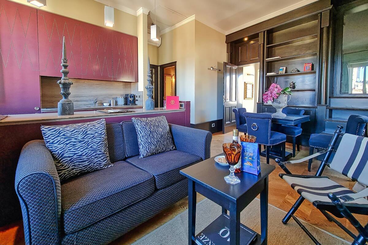 A modern living room with a sofa, a coffee table, and a dining area with chairs.