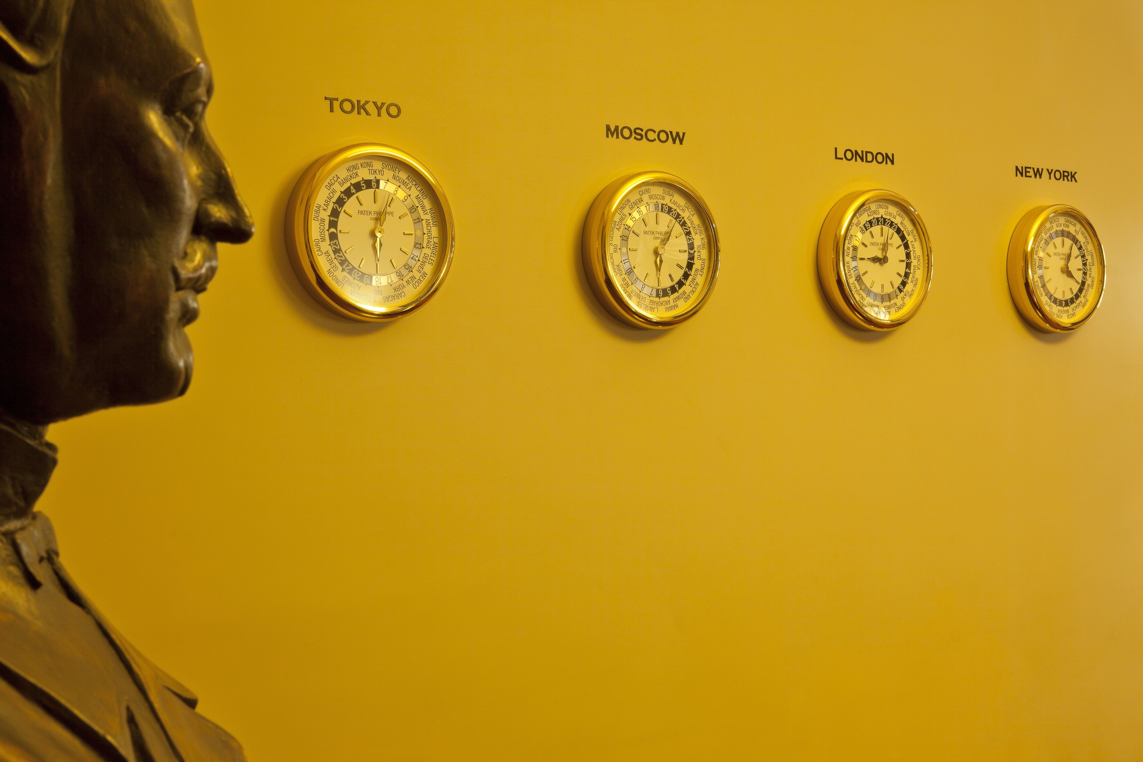 Una parete con quattro orologi etichettati con nomi di città: Tokyo, Mosca, Londra e New York.