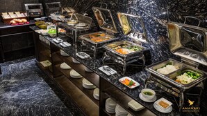 Un buffet proposant différents plats, avec plusieurs présentoirs où sont servis le riz, les légumes et diverses sauces.