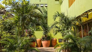 Een gebouw met een groene gevel, meerdere balkons en een binnentuin met potplanten.