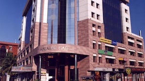 A hotel with a prominent entrance, multiple floors, and a mix of glass and brick facade.