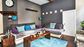Ein modernes Wohnzimmer mit einer Couch, einem Couchtisch und einer Wanduhr.