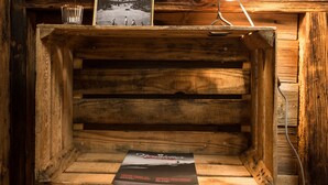 A rustic wooden desk with a desk lamp, a framed photograph, and a magazine on it. - Arena Lodge (Flims)