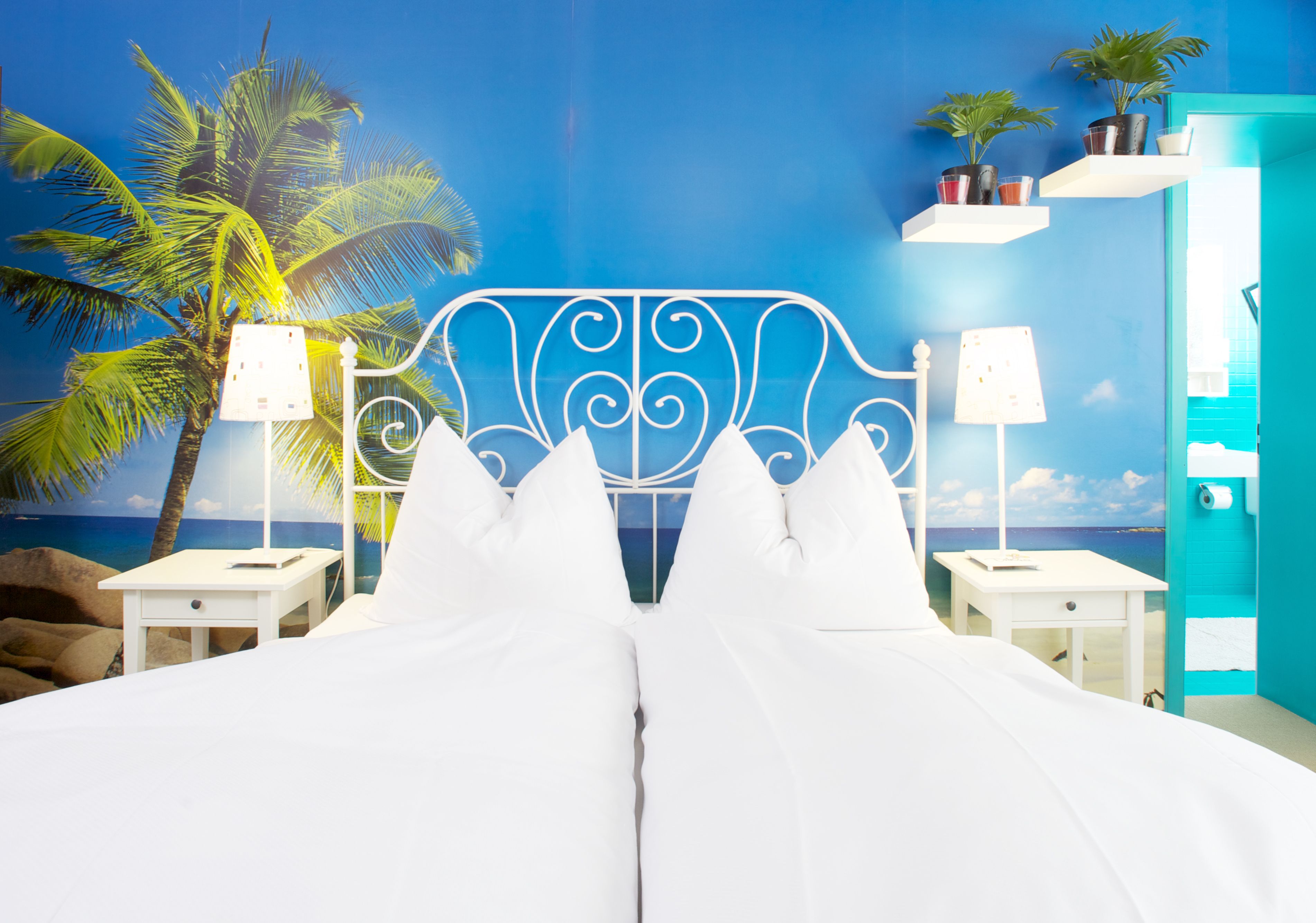 A bed with white linens, a decorative headboard, and two bedside tables with lamps.