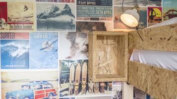 A room with a bed, posters on the wall, and a wooden headboard.