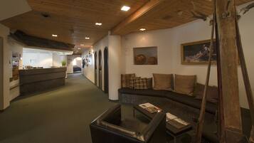 A hallway with a sofa, a coffee table, and a ski lift in the foreground.