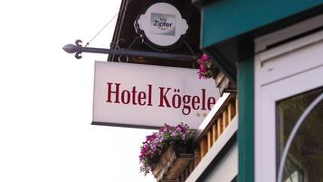 Un letrero de hotel con el nombre 'Hotel Kögele' y un letrero que dice 'Ziviler' encima.