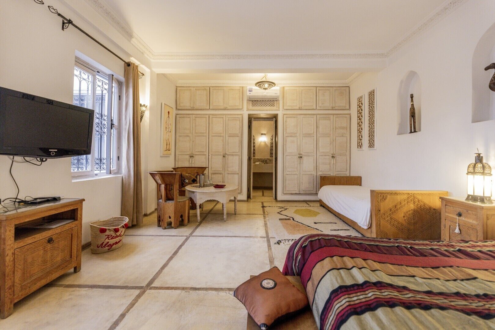 Une chambre à coucher comprenant un lit, une télévision, un bureau et une armoire.