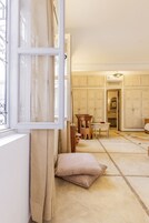 Una habitación con un ventanal grande, una mesa de madera, una silla y una cama.