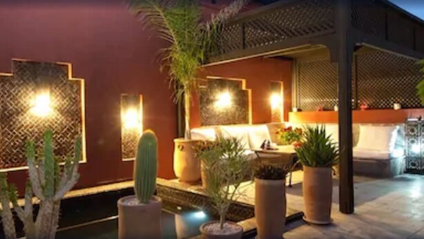 Un espace extérieur accueillant, aménagé avec des sièges confortables et une piscine, le tout agrémenté de plantes en pot et d’un éclairage décoratif.