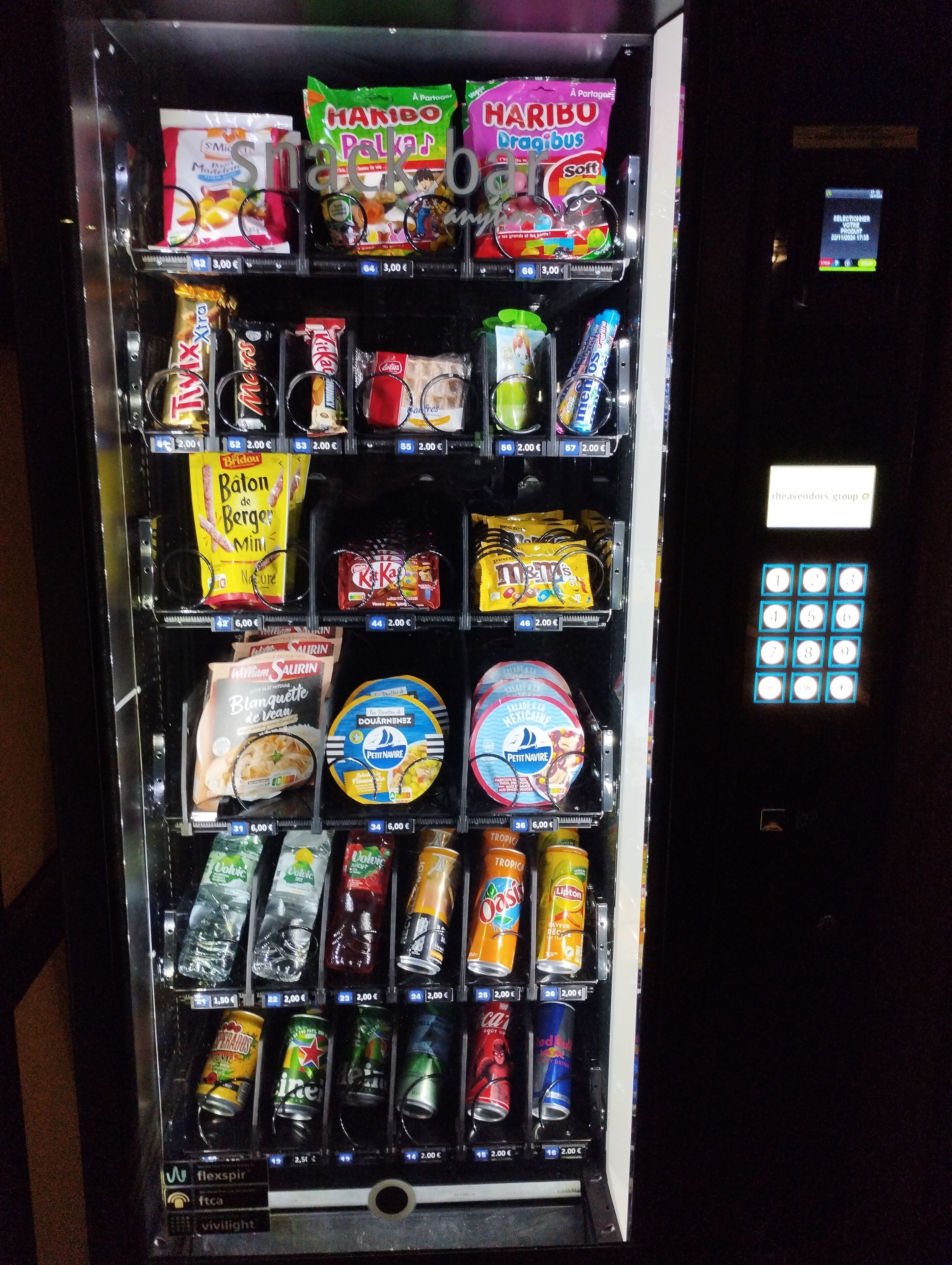 A vending machine with various snacks, drinks, and ice cream options.