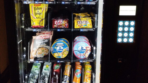 Máquina expendedora con diversas opciones de aperitivos, bebidas y helados.
