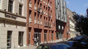 Un edificio con un letrero que dice 'Carat Shop', fachada de ladrillo y un cielo azul despejado.