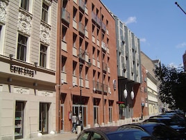 A building with a 'Carat Shop' sign, a brick facade, and a clear blue sky.