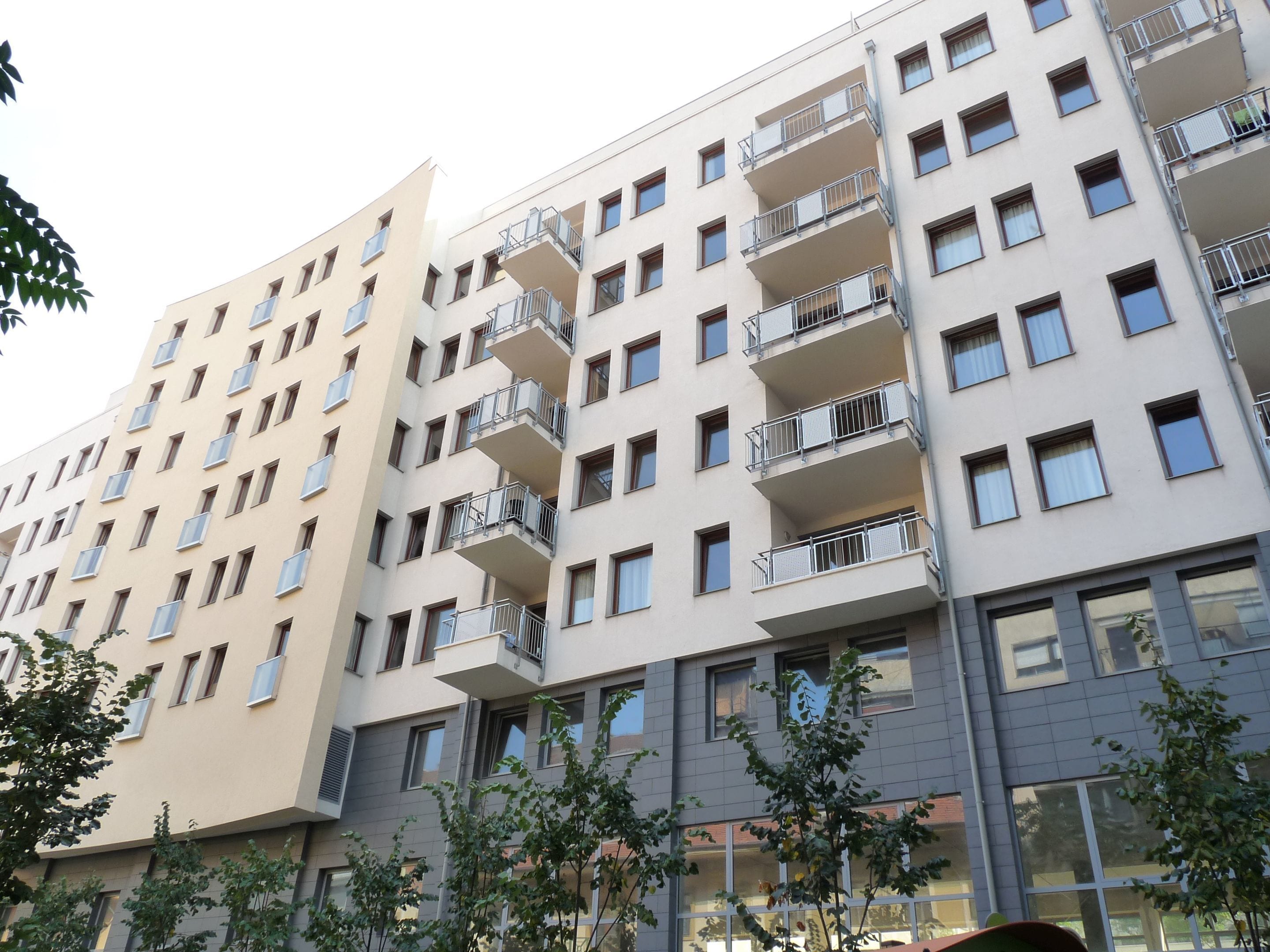 A multi-story residential building with balconies, large windows, and a modern architectural design.