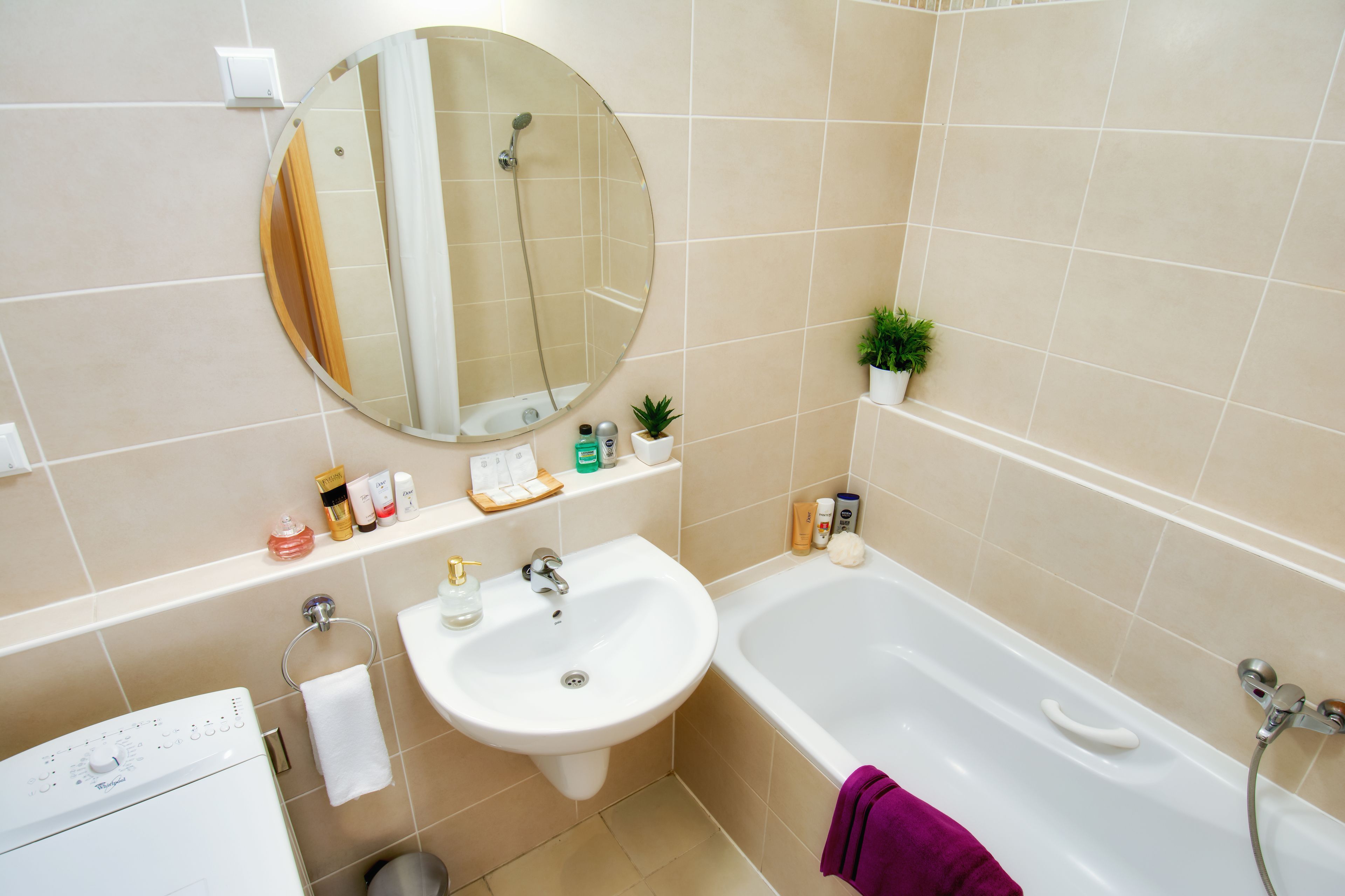 A bathroom with a sink, mirror, and bathtub.