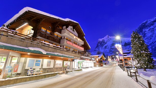 A hotel with a wooden facade, balconies, and a sign reading "HOTEL GRINDELWALDERHOF". - Grindelwalderhof (Grindelwald)