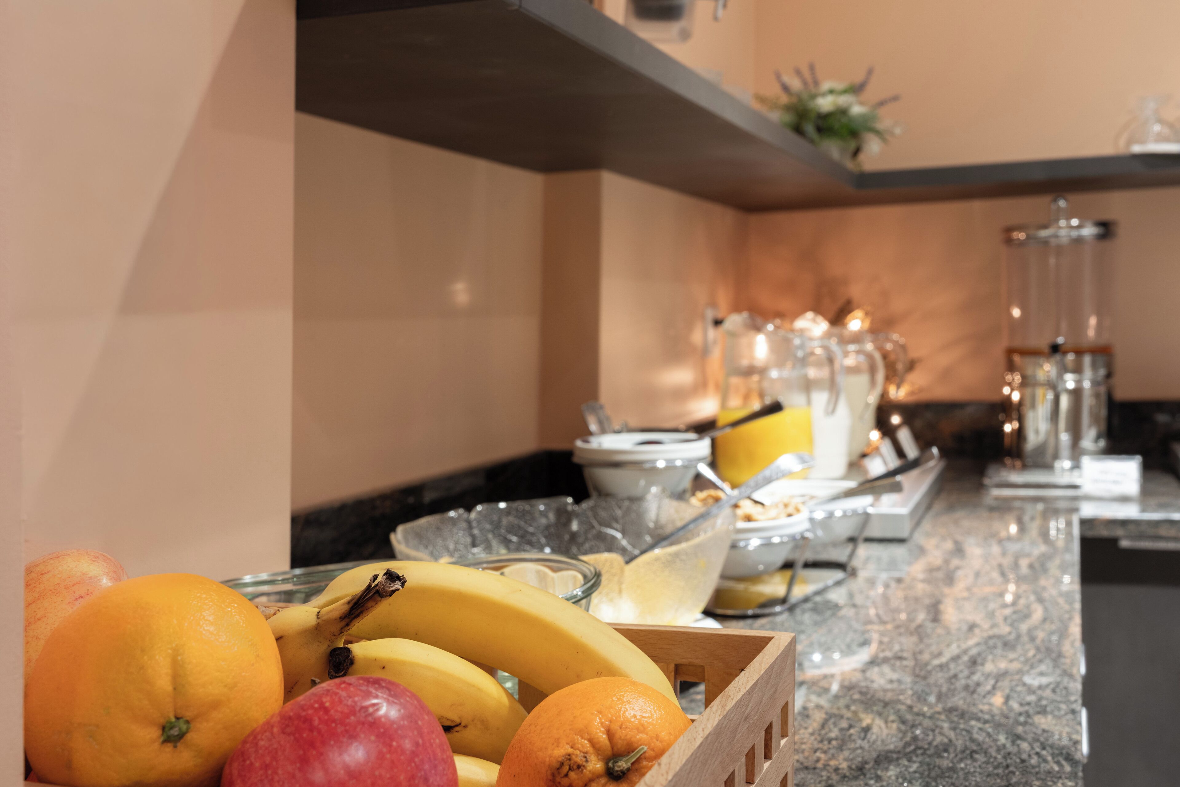 A breakfast bar with fruits and a coffee station.