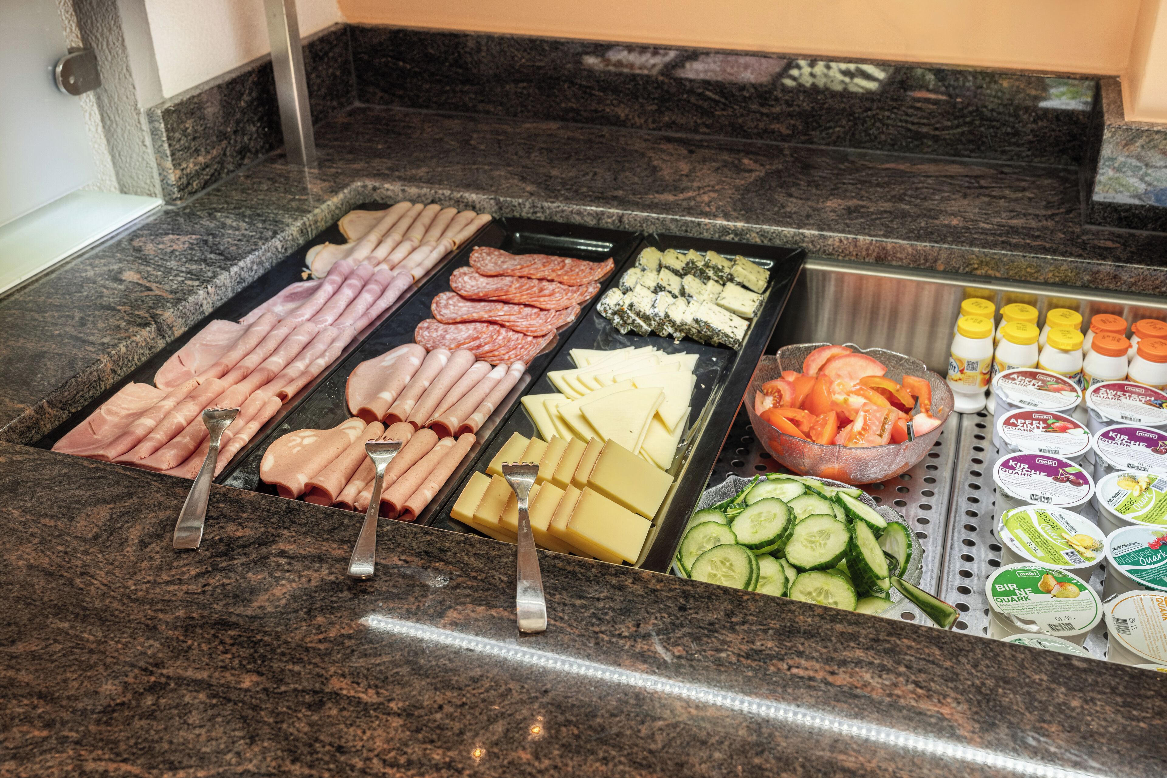 Un buffet proposant une variété de viandes, de fromages et de légumes.