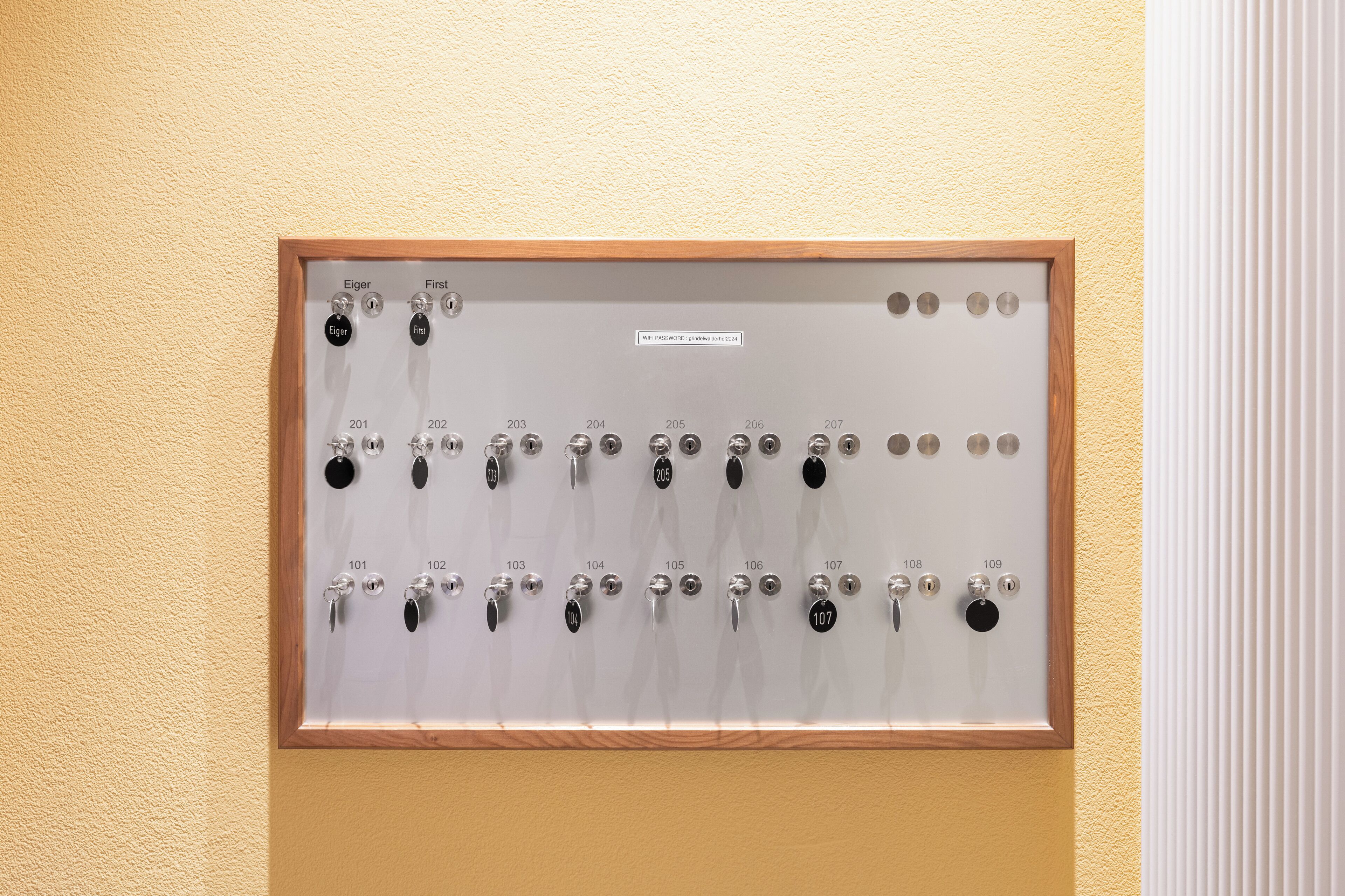 Ein an der Wand montiertes Bedienfeld mit nummerierten Tasten und Beschriftungen, vermutlich für den Zimmerzugang oder Hotelservice.