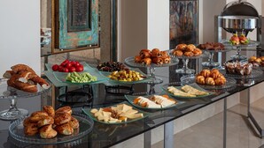 Un bufé con diversas opciones de comida, incluyendo pasteles, quesos y frutas.
