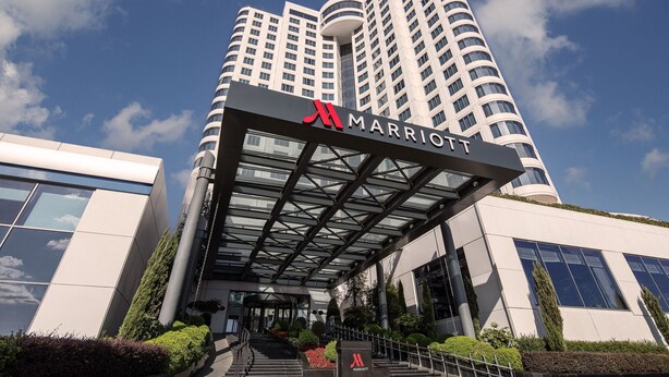 Un hotel Marriott moderno con entrada de cristal y un logotipo destacado.