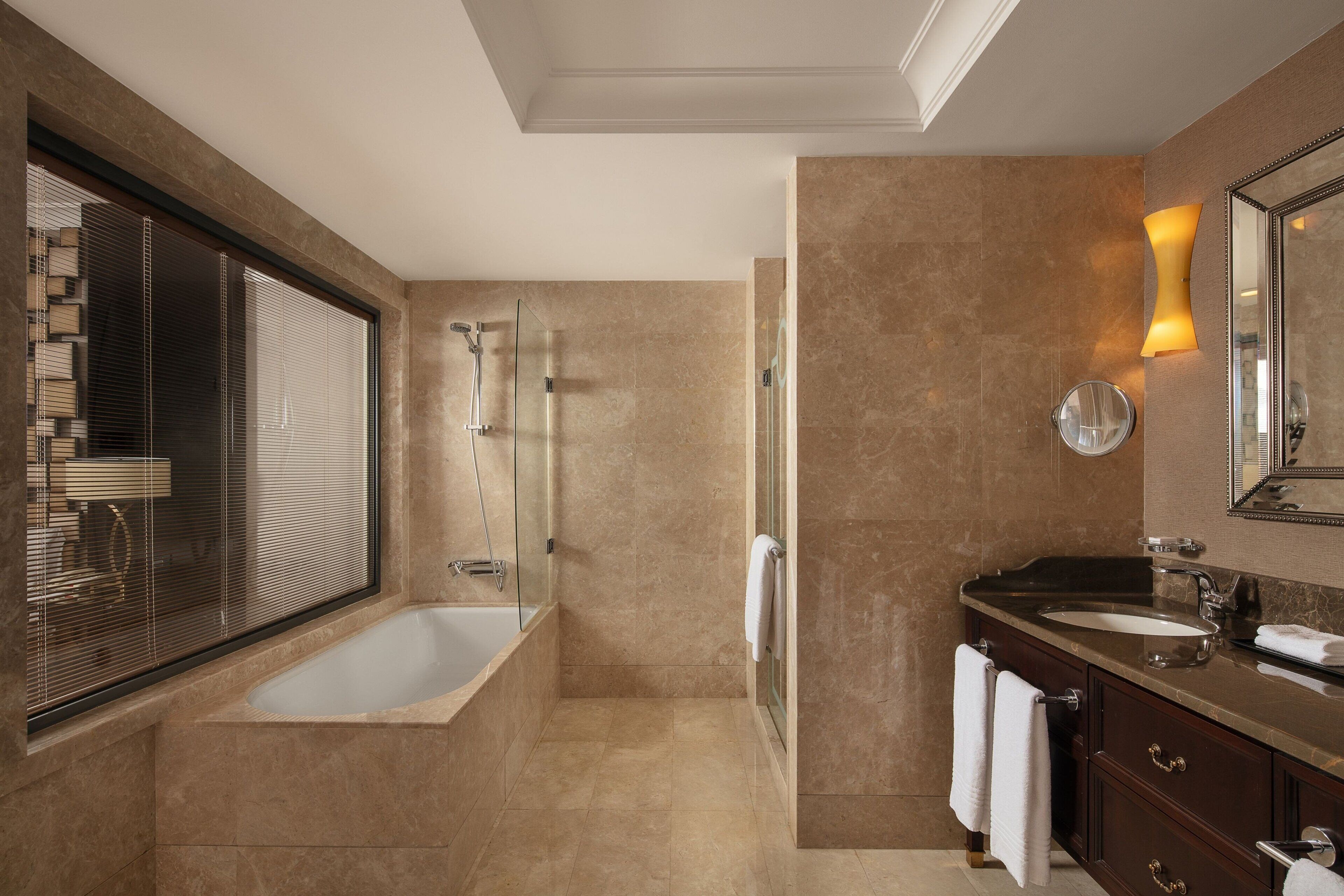 A modern bathroom with a bathtub, a shower, and a vanity with a mirror.