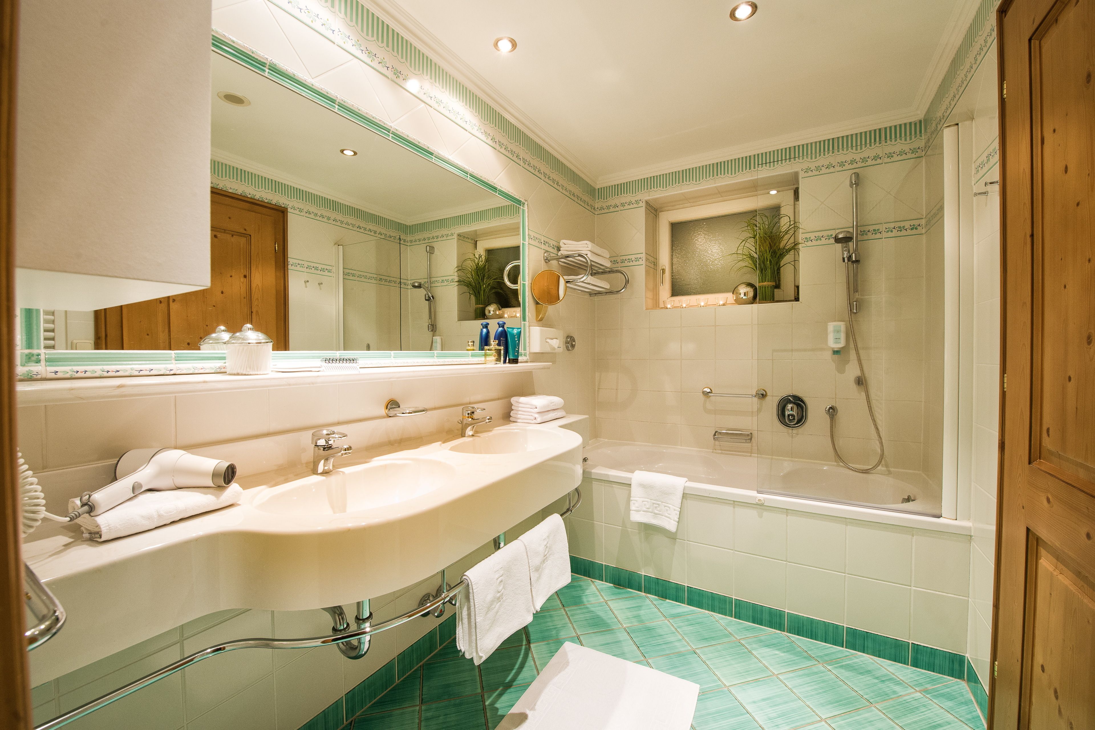 A bathroom with a double sink, a bathtub, and a shower.