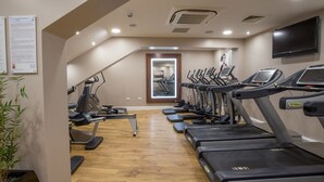 A gym with treadmills, elliptical machines, and a mirror. - DoubleTree by Hilton Milton Keynes (Milton Keynes)