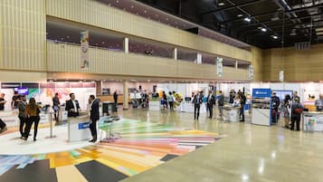 A spacious exhibition hall with multiple booths and attendees.