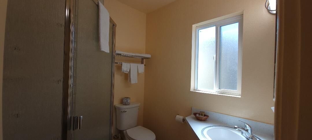 Un bagno piccolo con il water, un lavandino, una finestra e un porta asciugamani.
